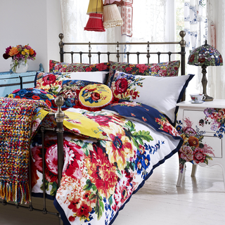 bedroom with white walls and floral printed bedding set on bed