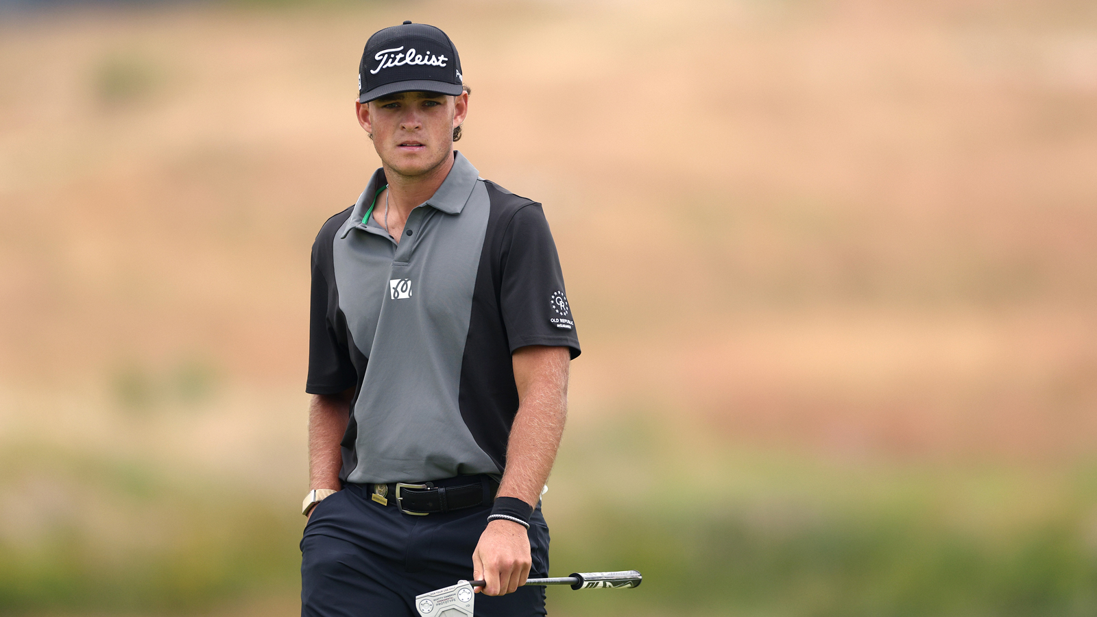 Jackson Koivun walks off the green holding a putter
