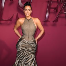 Kim Kardashian wearing an updo hairstyle and a neutral toned halter neck dress