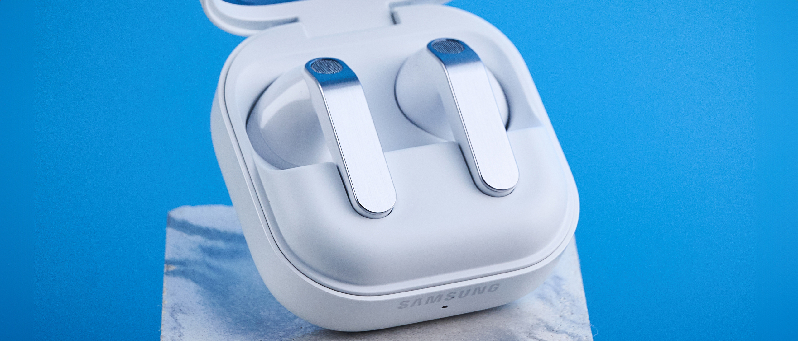 the samsung galaxy buds 4 photographed against the blue tom's guide background showing charging case and buds