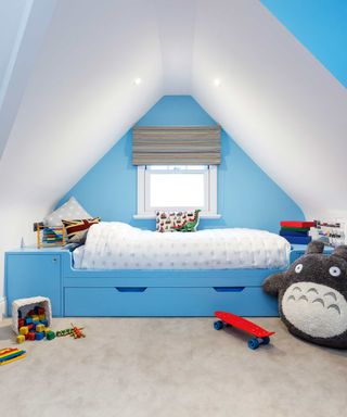 Blue attic bedroom with bed built into eaves