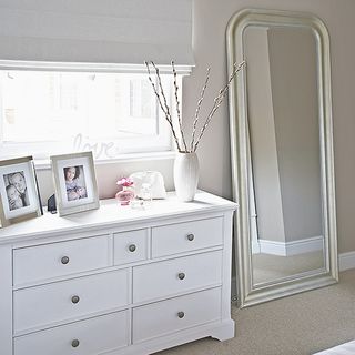 room with grey wall and white chest and floor mirror and white window with blinds