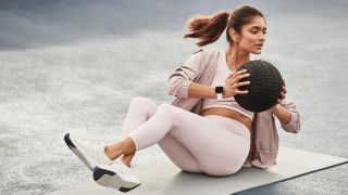 Woman working out wearing Fitbit Versa 2 fitness tracker