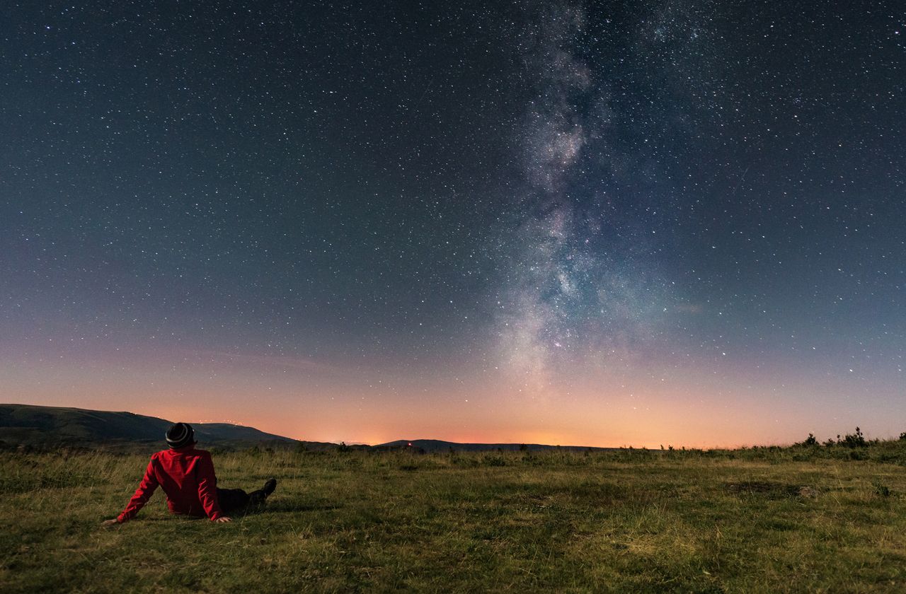 A young man lying on the grass and watching the Milky Way. Taken in A Veiga, Orense.