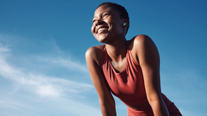 a woman in workout wear outside looking happy