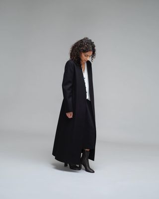 Neelam Ahooja wearing a long black maxi coat