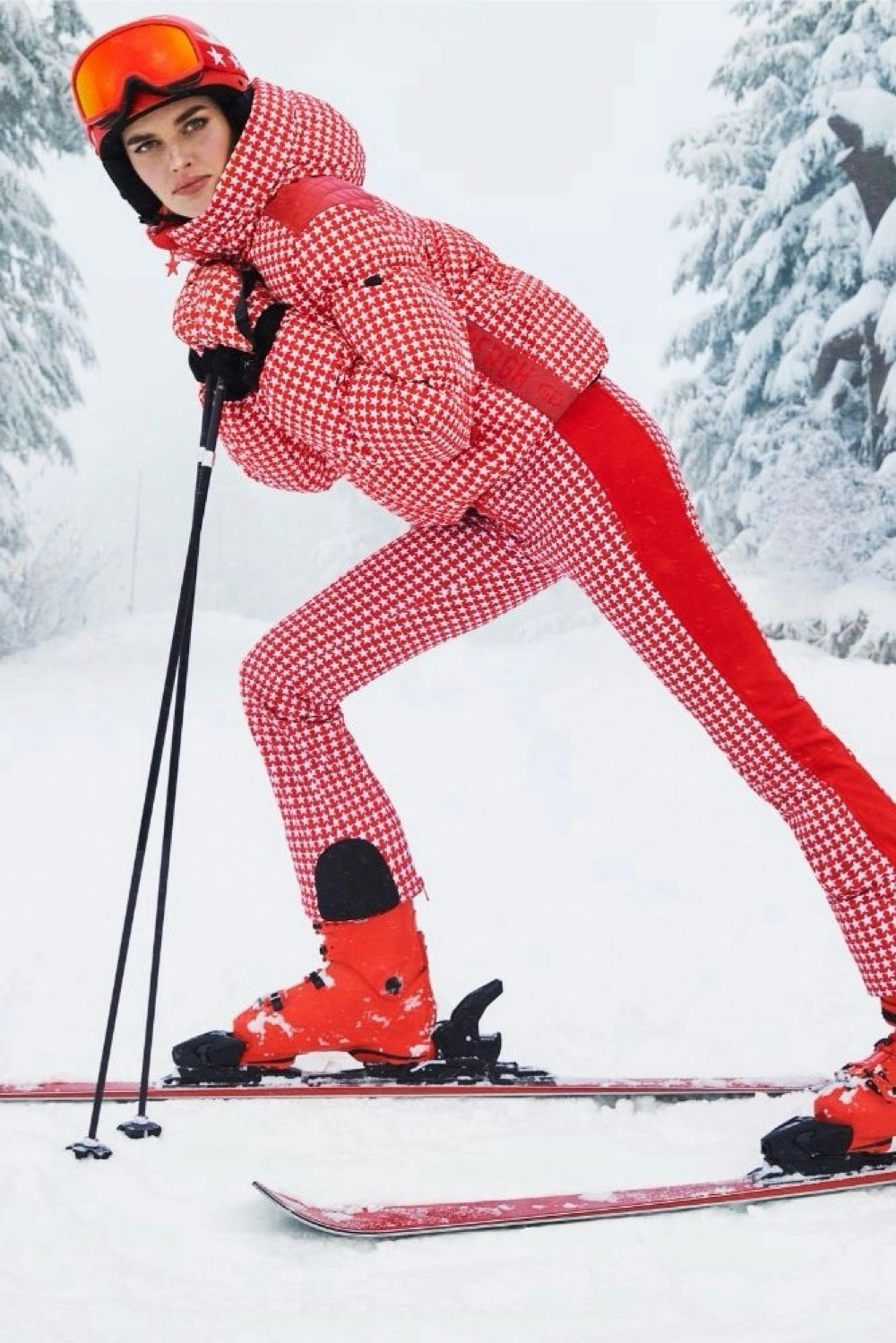 a model wearing a red and white ski suit available to rent from by rotation