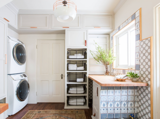 Butcher block countertop in white laundry room. The space also has extra storage for towels near the countertop.