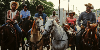the cast of Concrete Cowboy on horses, including Caleb McLaughlin and Idris Elba