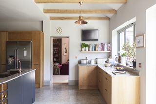A kitchen extension with exposed beams and oak units