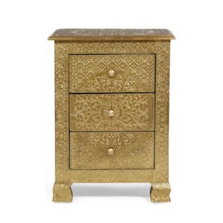 A gold nightstand with three drawers