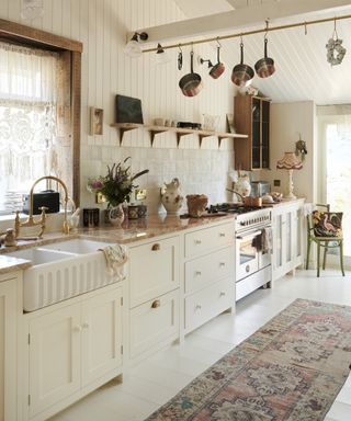 A white kitchen with off-white scandinavian cabinets, orange marble countertop and shiplap walls