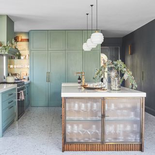green kitchen with reeded glass cabinet doors on the island