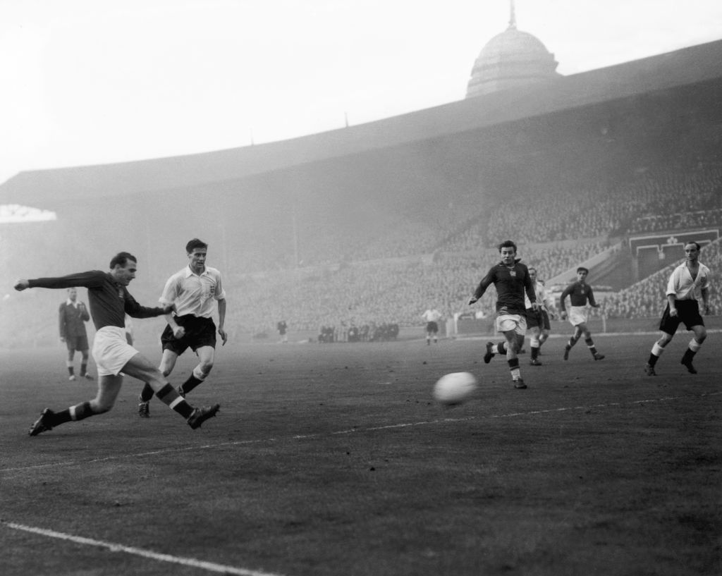 Hungarian centre-forward Nandor Hidegkuti (1922 - 2002) scores his team's 6th goal in the match against England at Wembley, 25th November 1953. England player Jimmy Dickinson (1925 - 1982) is also visible. Hungary won the match 6-3. (Photo by Dennis Oulds/Central Press/Getty Images)