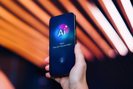 A hand holding a phone with AI on the screen 