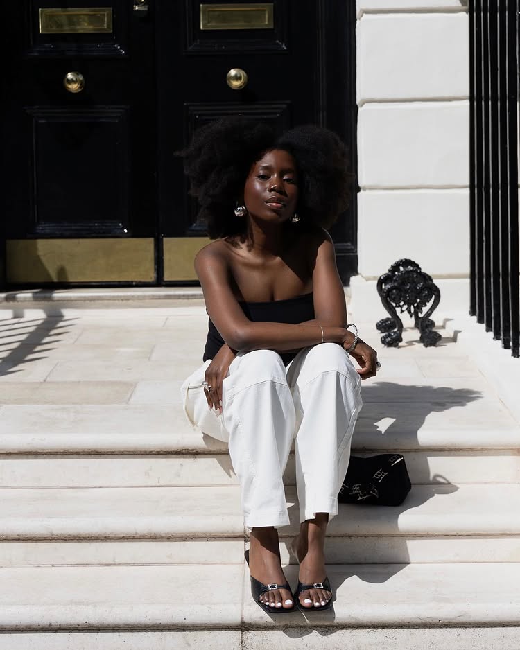 @daniellejinadu wears a pair of mule sandals with white trousers and a black bandeau top