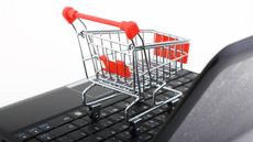 Tiny shopping trolley on a laptop keyboard