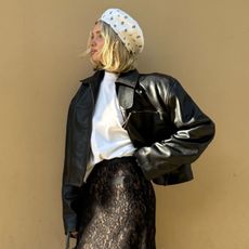 Elsa Hosk wearing a white hat and T-shirt with a leather bomber jacket and lace skirt.