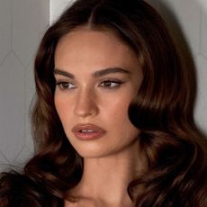 Lily James with shiny, wavy brunette hair