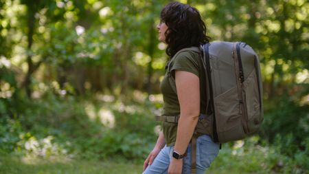 The Peak Design Travel 2-in-1 Backpack outdoors used by a photographer