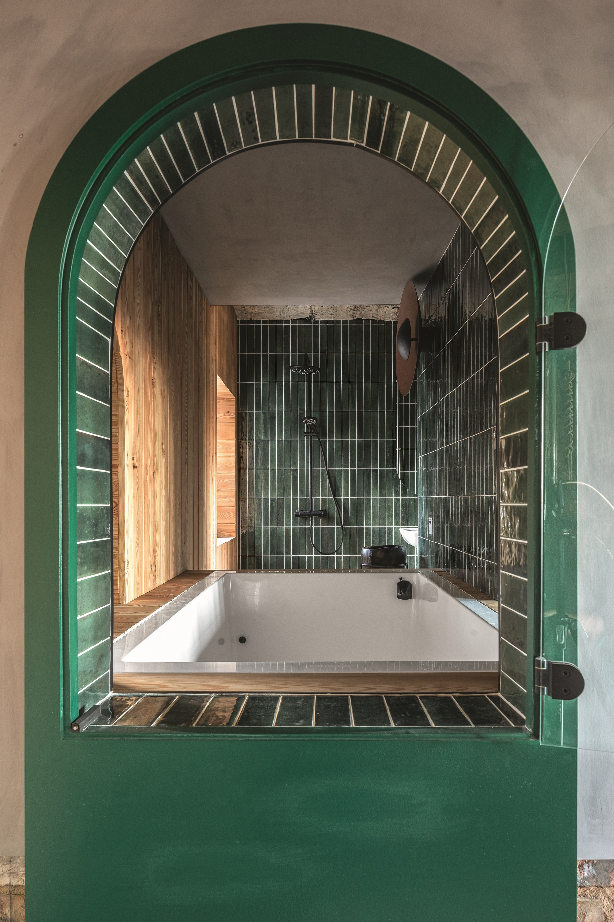 Two-person Japanese-style soaking tub by Omni Tub. Origin shower, bath, and basin taps and fittings in matte black by Vitra