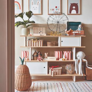 A children's room with a shelf unit displaying toys, decor and storage boxes