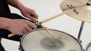 Man playing drums with a set of the best drumsticks