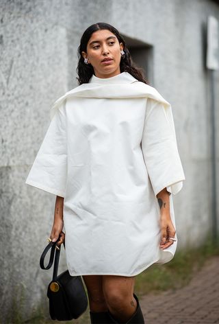 Milan fashion week spring 2025 street style photo of a woman wearing draped neckline trend