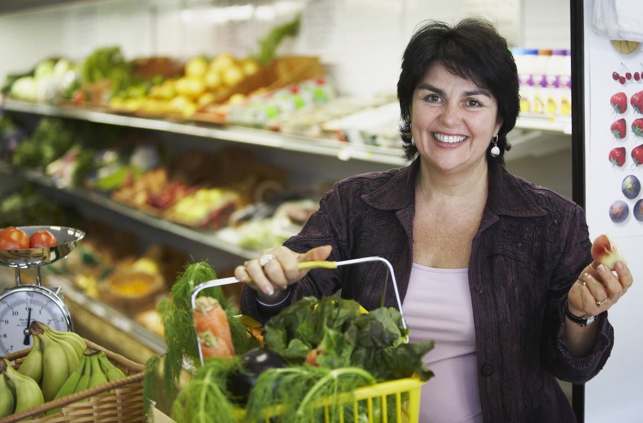 Portrait of a mature woman holding a shopping basket and smiling