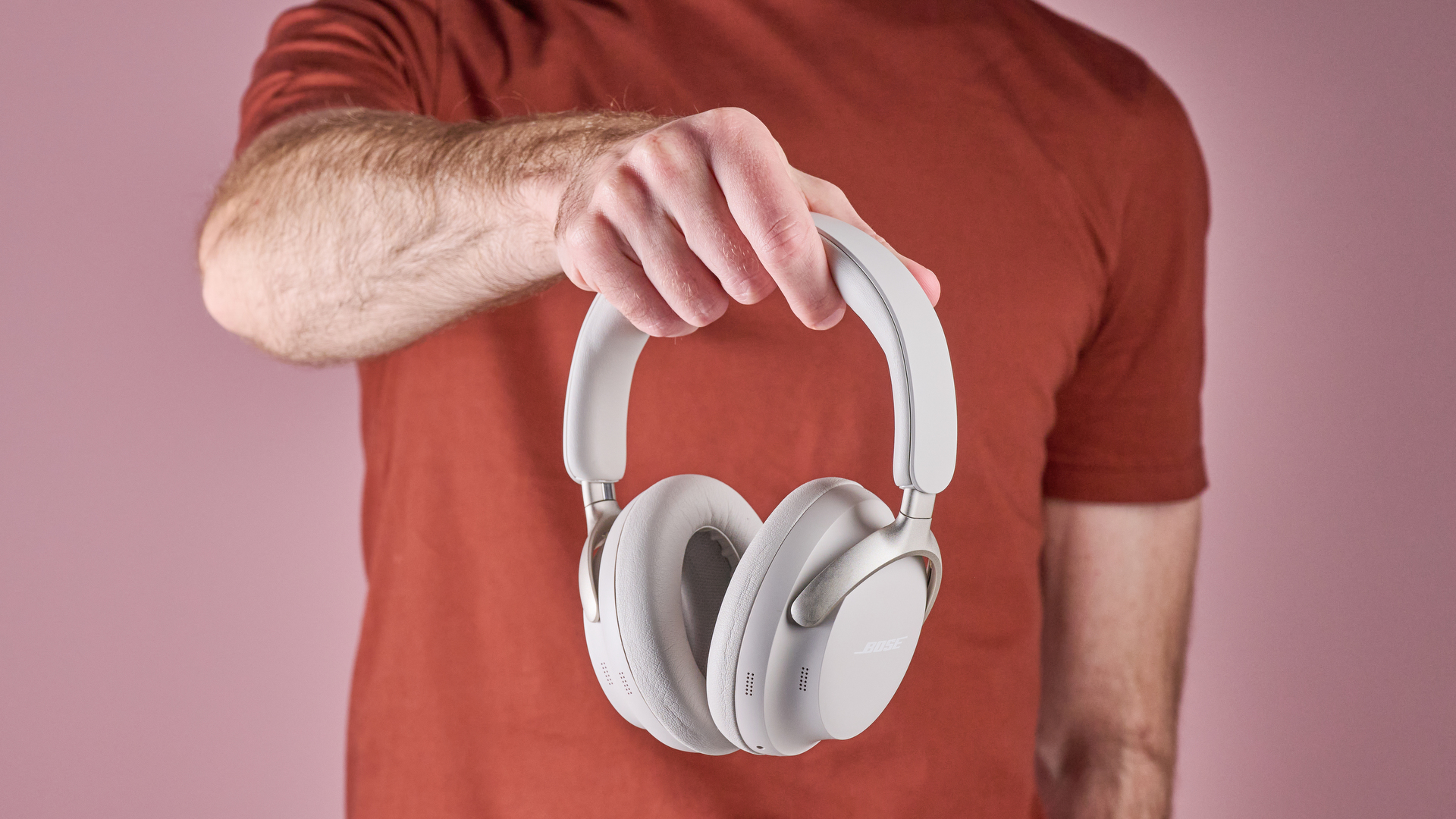 Bose QuietComfort Ultra Headphones held in a man's hand