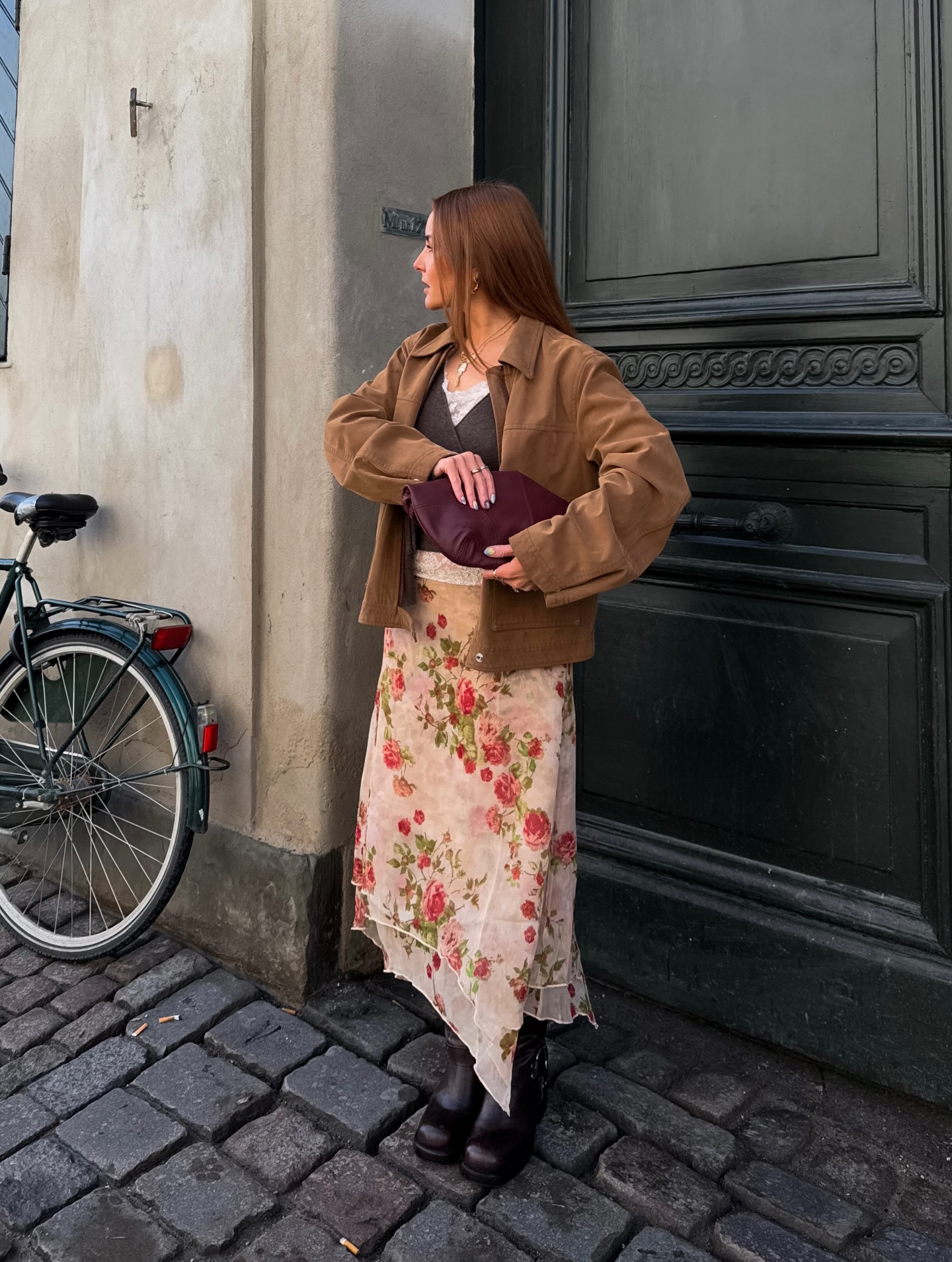 rebecca ferrazwyatt wears a brown jacket, grey jumper, floral print skirt and leather boots