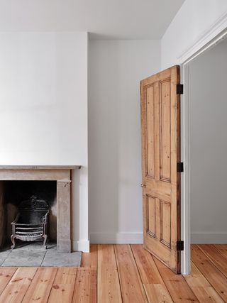 white walls and timber door and fireplace in london home interior