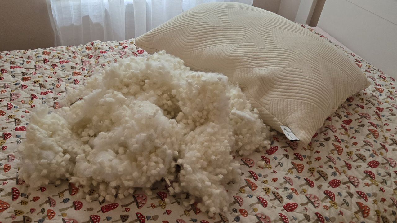 Coop Sleep Goods Adjustable Latex Pillow with nearly one pound of fill removed, placed next to the pillow