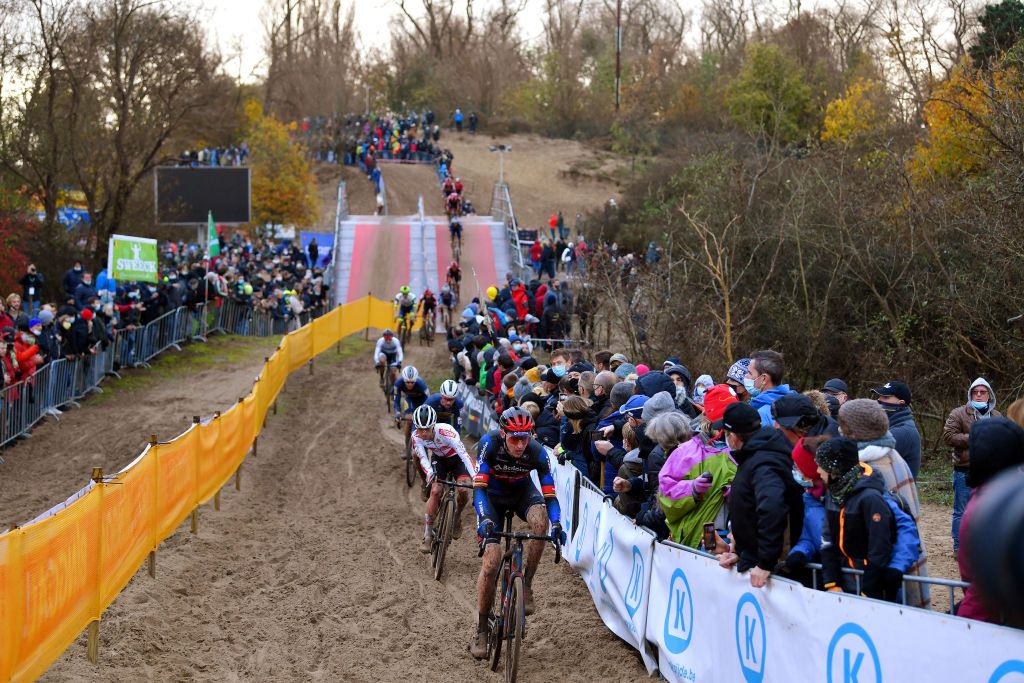 KOKSIJDE BELGIUM NOVEMBER 21 A general view of Toon Aerts of Belgium and Team Baloise Trek Lions Eli Iserbyt of Belgium and Team Pauwels Sauzen Bingoal and Vincent Baestaens of Belgium and Team DeschachtGroup HensContainers Maes competes while fans cheer during the 50th Koksijde UCI CycloCross Worldcup 2021 Mens Elite CXWorldCup on November 21 2021 in Koksijde Belgium Photo by Luc ClaessenGetty Images
