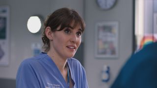 Jodie's face lights up when Dylan offers his professional support during a tough shift at Holby ED.