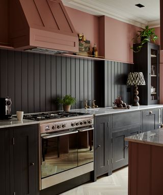 dark gray kitchen with pink walls and cooker hood