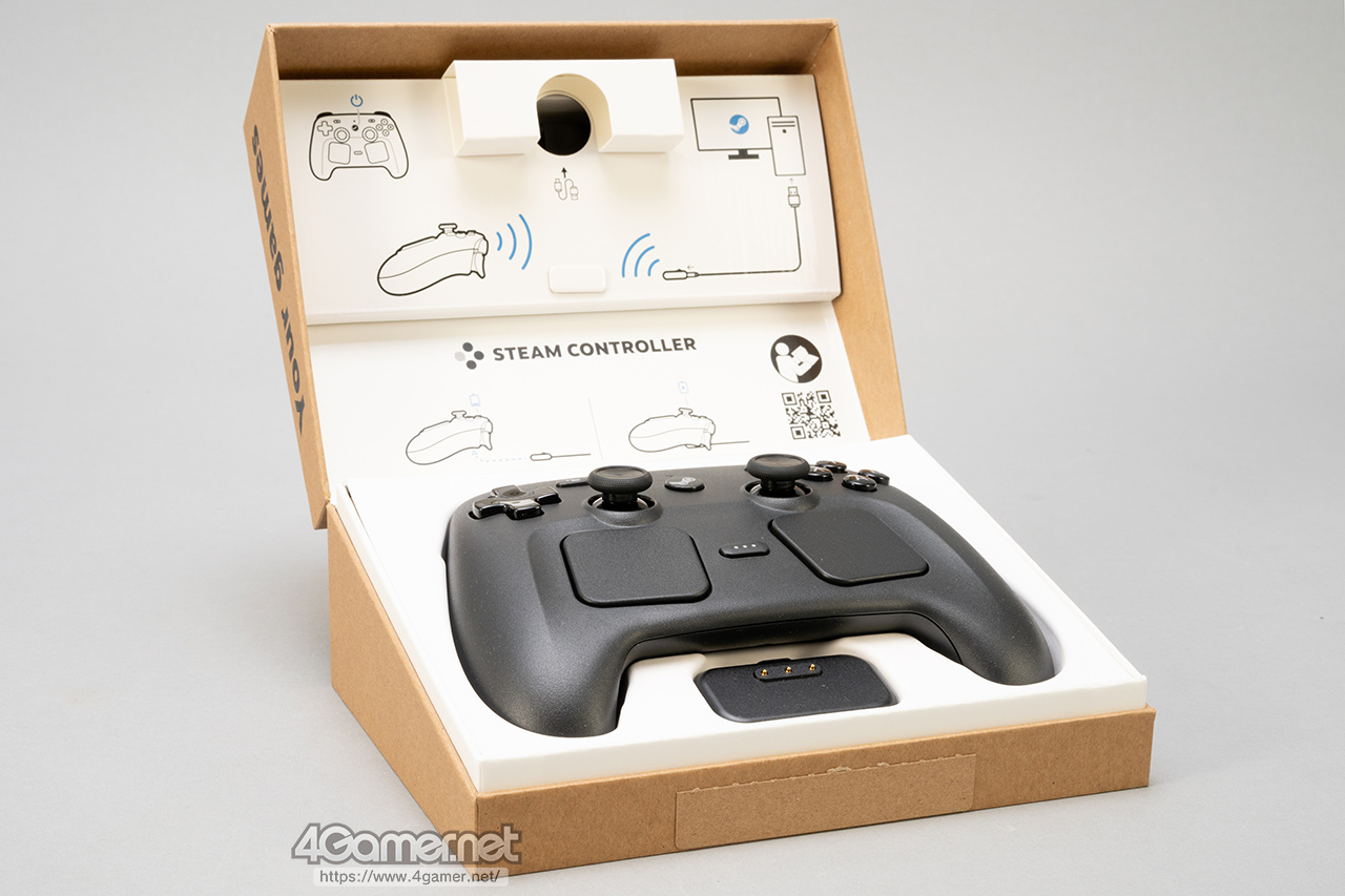 An open cardboard box displays a black Steam Controller with dual trackpads. Instructional diagrams are printed inside the box lid.