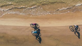 Drone view of riders on a beach in Tuscany