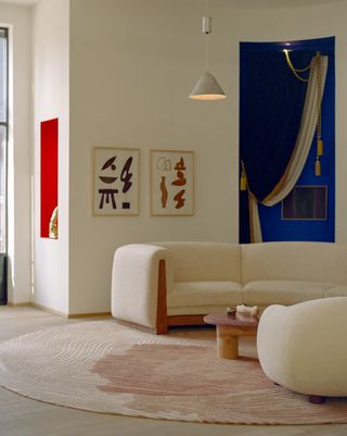 A living room in beige walls and sofas, and and royal blue corner