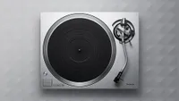The Technics SL-1500C turntable, photographed top-down from above, on a gray textured background