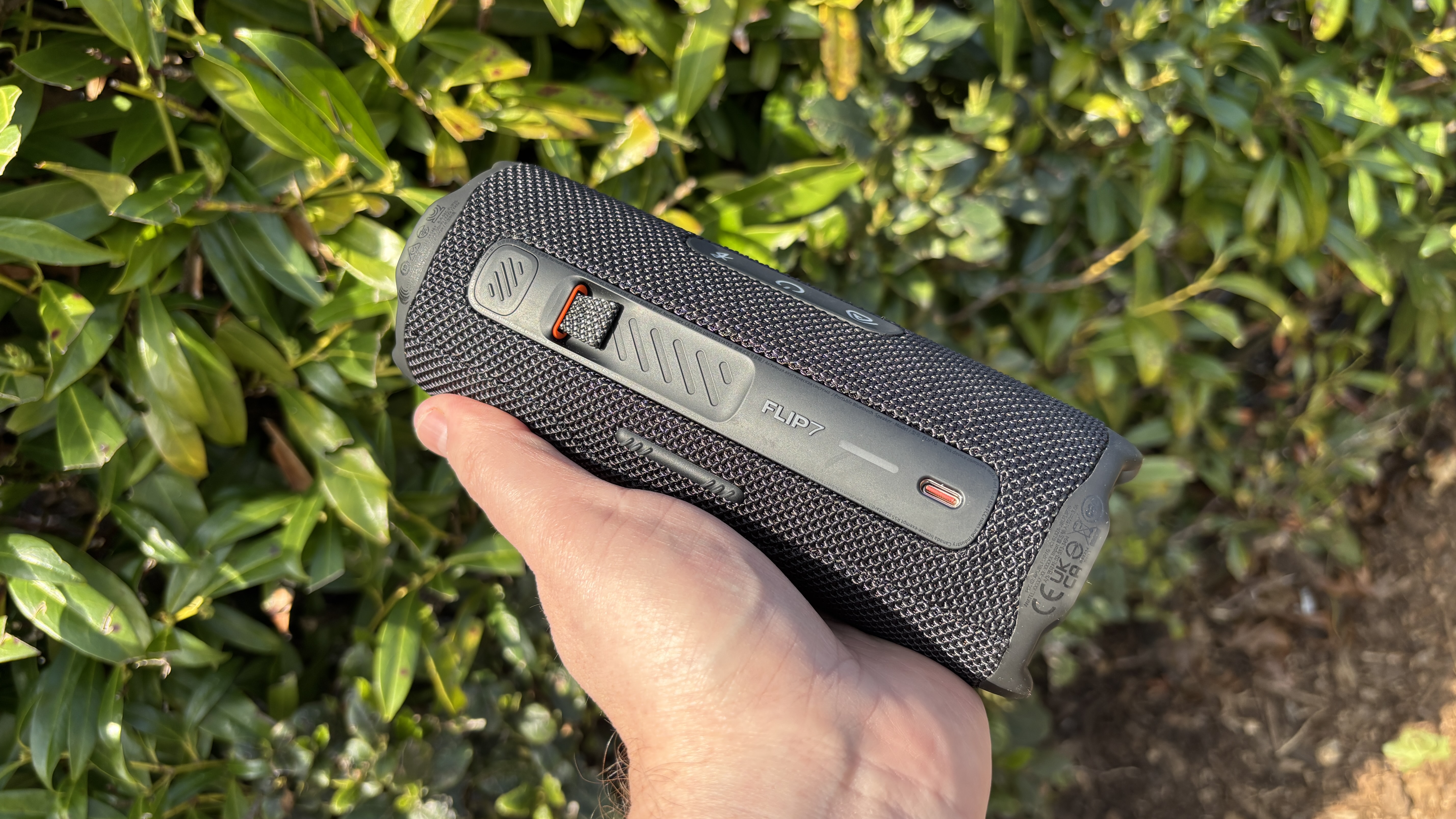 Rear picture of a JBL Flip 7 held in a man's hand