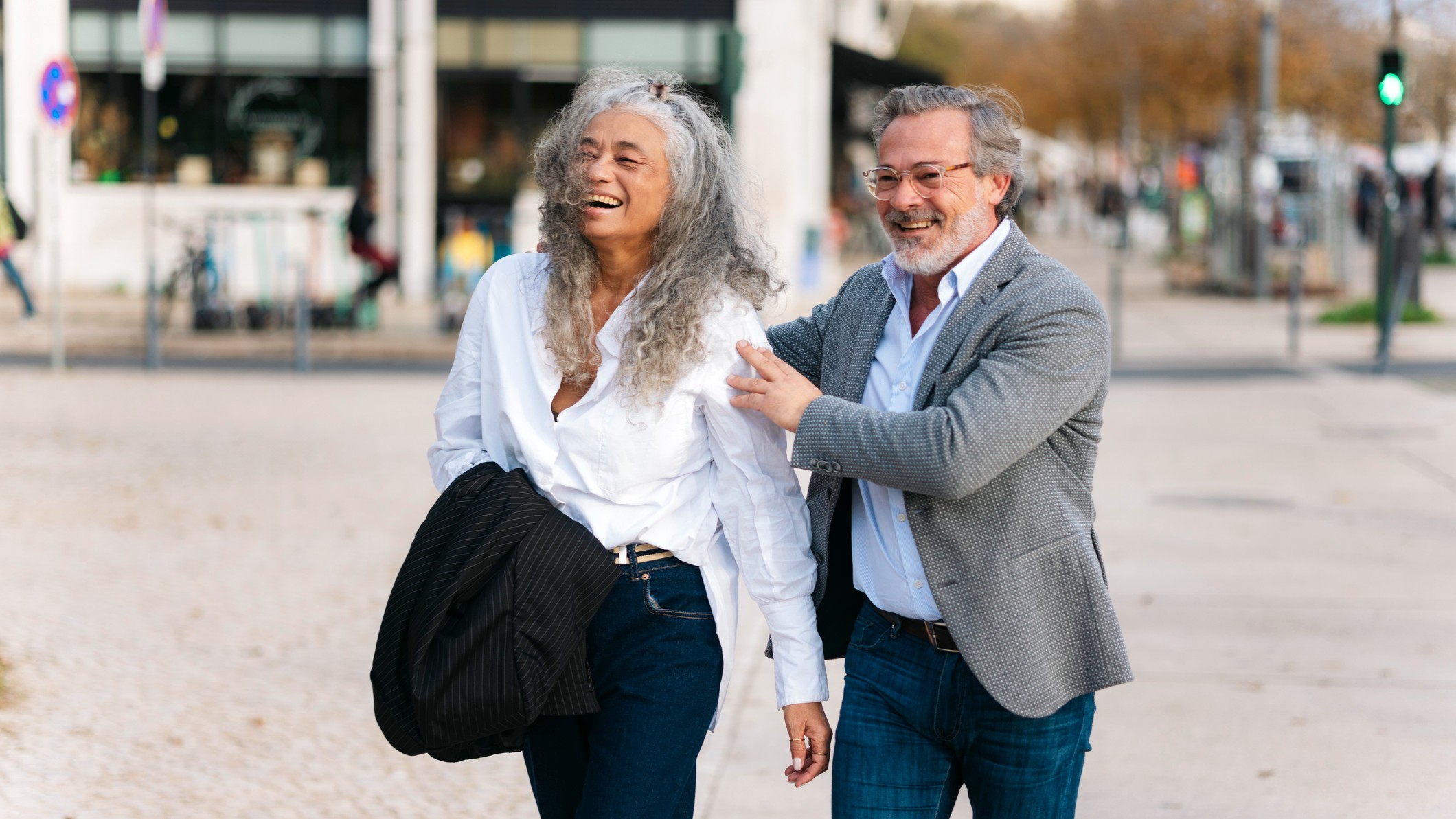 Cheerful senior couple walking down the street, traveling, having a good time together