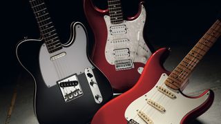 A Telecaster and two Stratocasters against a shadowy background