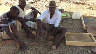 Akai Ekes and John Ekusi watch as Isaiah Nengo lifts the sandstone block with Alesi after six hours of excavation.