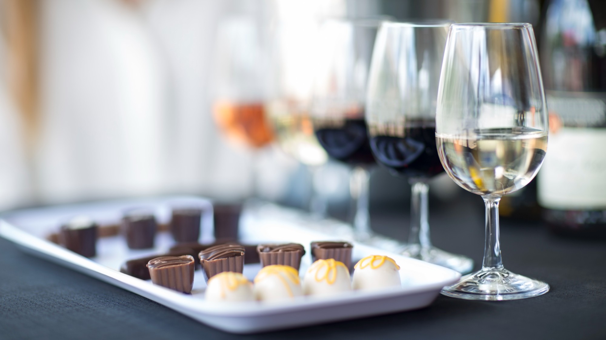 A stock photo of chocolate samples next to wine glasses. 