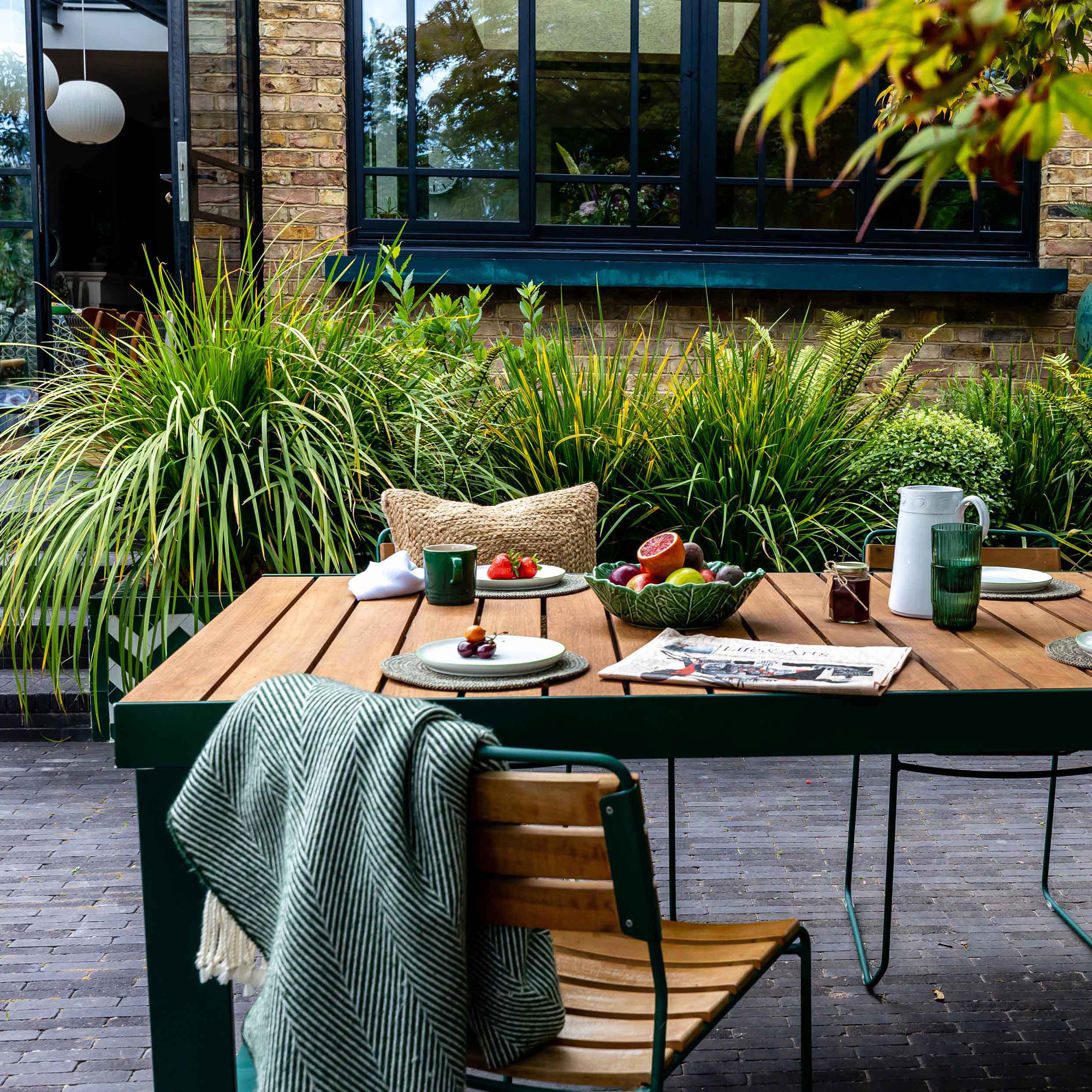 garden makeover with a grey tiled patio with dining table and chairs