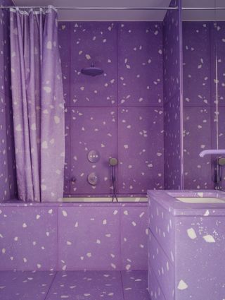 A bathroom with purple tiles and dark purple grout