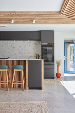 black kitchen with timber cladding on ceiling