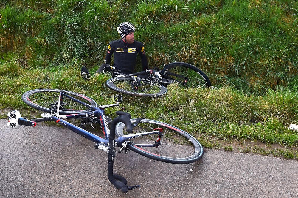 Matt Goss lays in a ditch after crashing during Dwars Door Vlaanderen.
