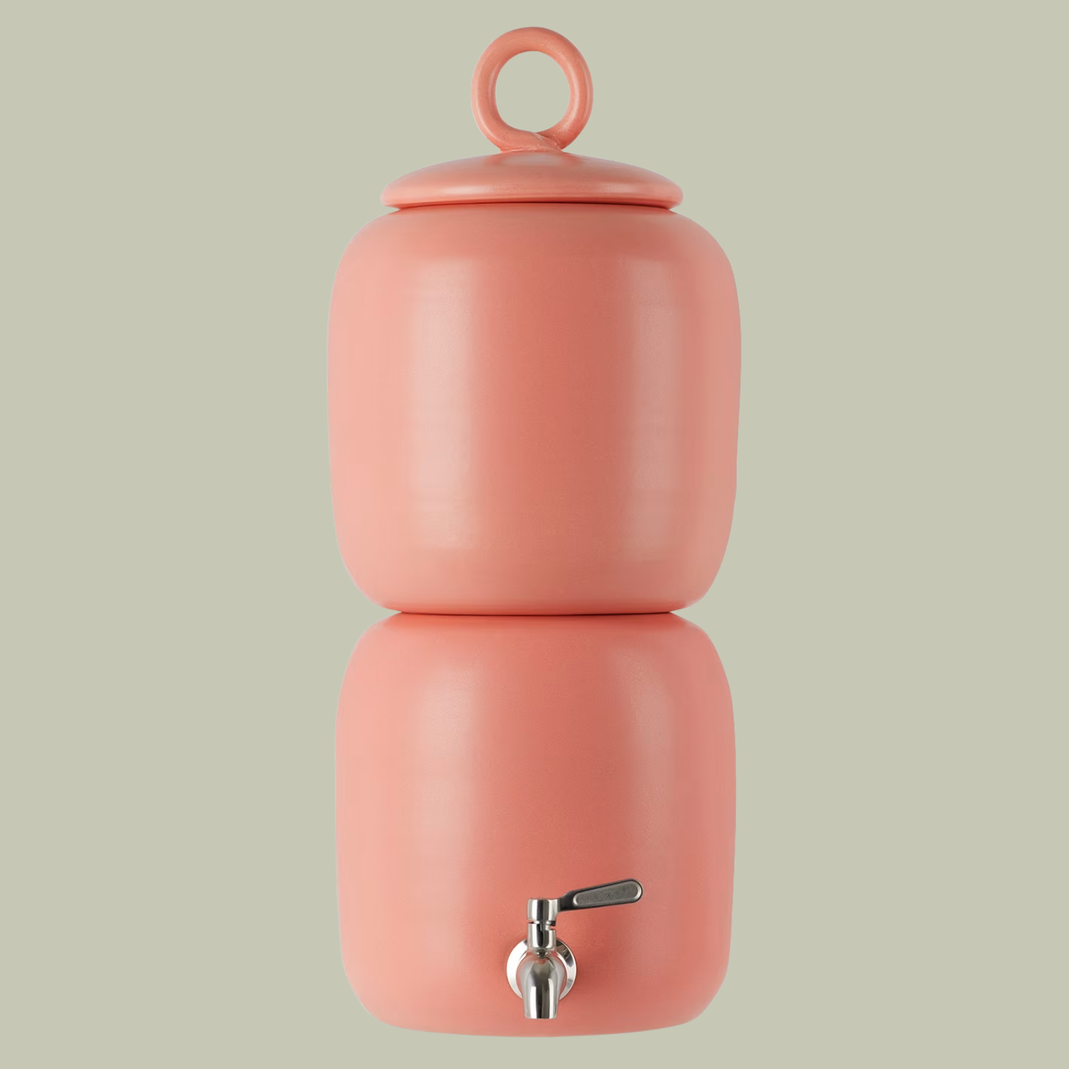 A peach pink ceramic water dispenser against a light green backdrop